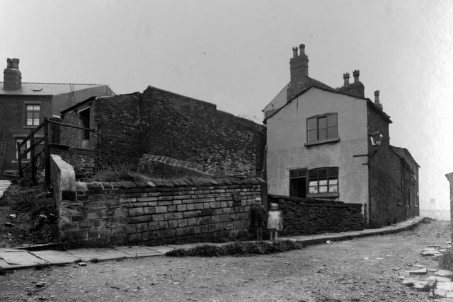 Part of Armley Road, showing tramlines, overhead cables, ornamental wrought iron street lamp, and large house with high wall around garden. Pictured in September 1937.