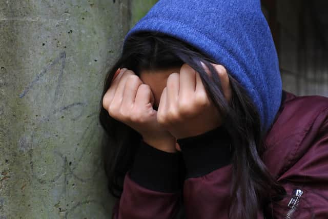 PICTURE POSED BY MODEL of a teenage girl with her head in her hands showing signs of mental health issues.