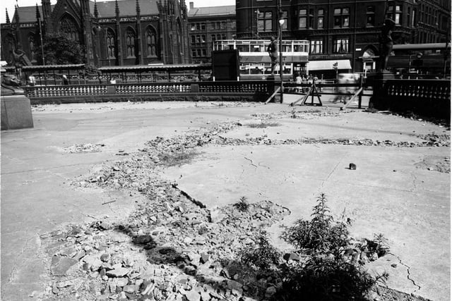 Damaged concrete on City Square in August 1947. The area is cordoned off and various statues are in the background. Mill Hill Chapel, Park Row, a coffee shop and a tram can be seen.