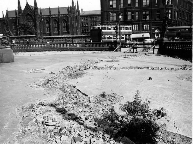 Damaged concrete on City Square in August 1947. The area is cordoned off and various statues are in the background. Mill Hill Chapel, Park Row, a coffee shop and a tram can be seen.