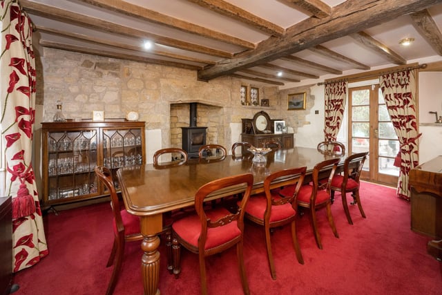 The formal dining room again exudes character with exposed stone walls and ceiling beams, fireplace with cast iron stove and double French doors opening out into the private courtyard.