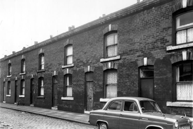 Albury Terrace in August 1961. Constructed of red brick, these houses are through and the back doors can be accessed on Albury Place. A child's tricycle stands outside number 13 and a car is parked on the cobbled street outside no 21.