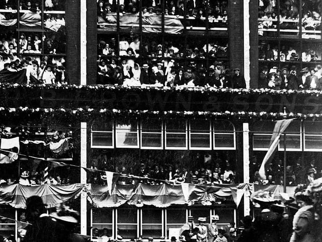 R.B. Brown & Sons, wholesale clothiers, on Wellington Street. The frontage of the building has been decorated in celebration of the Royal visit. Every possible vantage point is occupied by workers of Brown's including the roof.