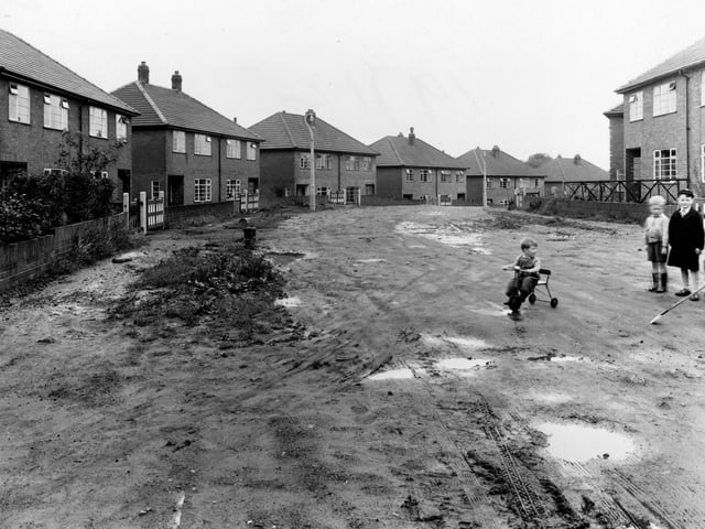 Newly built houses on Allerton Grange Gardens in August 1954. To the right is a group of small children. One is riding a tricycle.