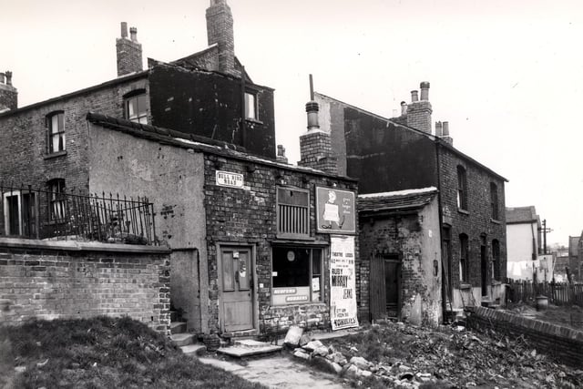 On the left edge of this photo in the background are properties on Life Guard Square in 1958. Moving forward Bull Ring Road with a small flight of steps to the left giving access to the square. This one storey building had been the premises of Edgar Broadley, boot repairer but now appears derelict.