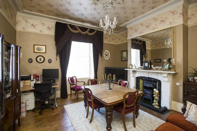 The dining room with original features including a ceiling rose and the marble fireplace.