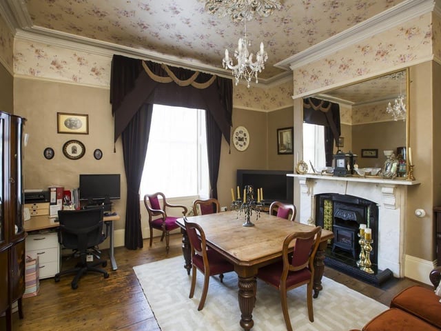 The dining room with original features including a ceiling rose and the marble fireplace.