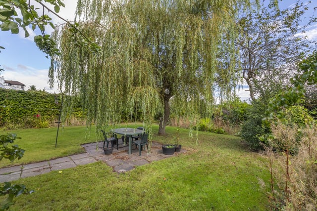 A beautifully presented garden completes the property, offering lawned areas, a paved seating area plus plants and trees.