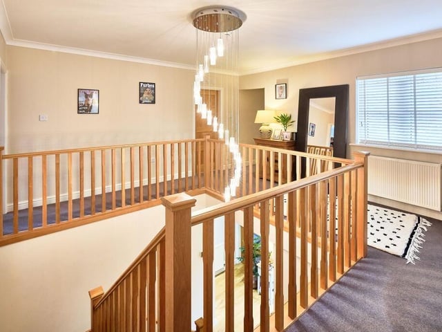 Stairs lead to the gallery landing on the first floor, which has a striking chandelier as the focal feature.