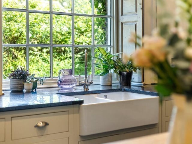 A classic double Belfast sink anchors the kitchen, combining traditional character with everyday practicality.