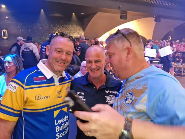 Leeds Rhinos coach Brad Arthur poses for a picture with two supporters.