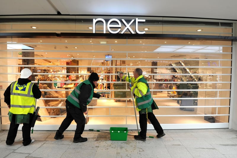 Cleaning the shutters of Next in preparation for the official opening of the centre.