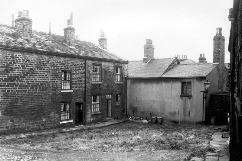 Two cottages which were part of Woodhouse Cliff pictured in September 1959. They were located at the end of Holroyds Yard, off Dairy Street. Next, the cement rendered building is the back of no's.30/31 Woodhouse Cliff. 'Woodhouse Cliff' referred to an area which ran from Woodhouse Ridge to Woodhouse Street, between Hyde Park, to Delph Lane. The road called Woodhouse Cliff ran in an irregular line roughly parallel to Woodhouse Street, between Cliff Road to Delph Lane.