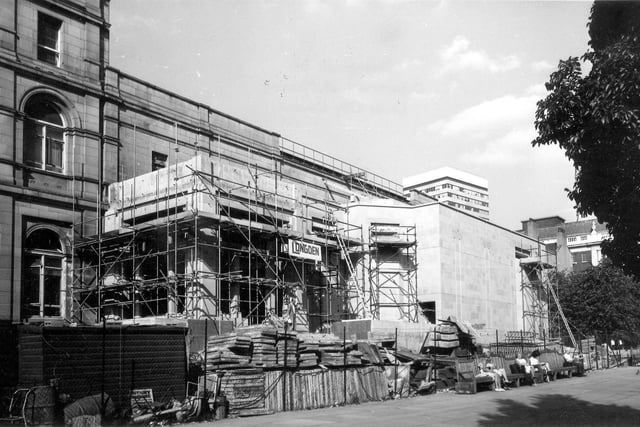 City Art Gallery on The Headrow during the construction of the Henry Moore Sculpture Gallery extension in September 1981. Named after the famous Castleford-born sculptor and former Leeds College of Art student who laid the foundation stone on 10th April 1980, the Gallery was opened in 1982. Despite the work in progress and scaffolding around the building, people are still relaxing on the seats in Victoria Gardens in front. The Municipal Buildings can be seen on the left.