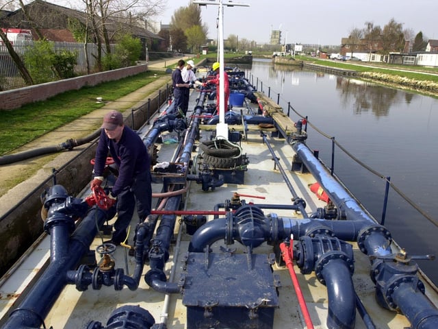 Bargemen deliver fuel to the Total Butler site by the Aire Calder Navigation on Lock Lane, Castleford, on April 3, 2002.
