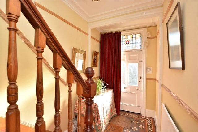 The ground floor entrance hall has tiled flooring and a staircase to the first floor, with original panelling below.