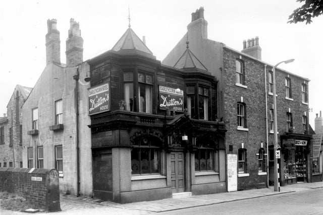 The Barleycorn Hotel pictured in July 1960. the landlord at the time was listed as James W. White. This pub is built in the Gothic revivalist style with decorative roof turrets above the upper front windows. It has now closed down. On the right edge, the premises of G. Bretherick and Sons, funeral directors, is just visible.