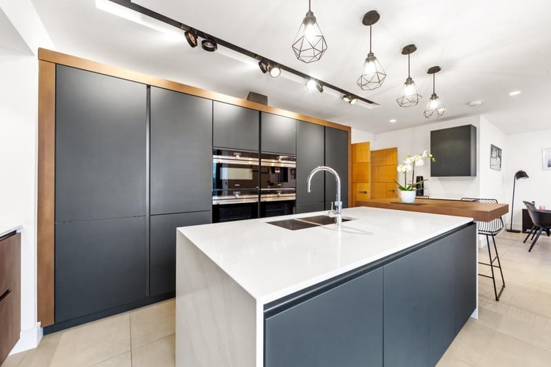 The sleek and modern kitchen has integrated Siemens appliances, and an island with breakfast bar.