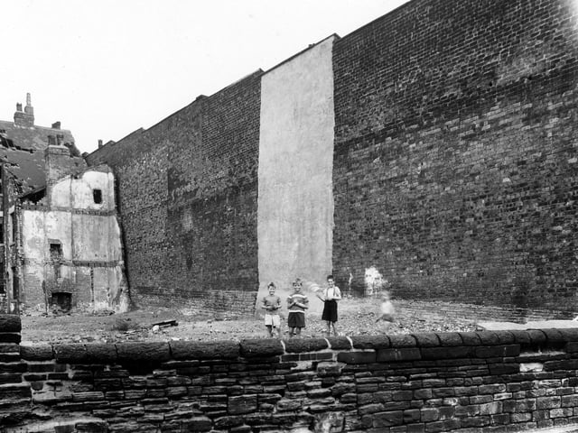 The end of Back Belle Vue Grove, the wall on the left is the back of houses on the even numbered side of Kendal Terrace. A row of houses had once stood where the boys are playing on waste ground, the end wall of one can be seen towards the left.