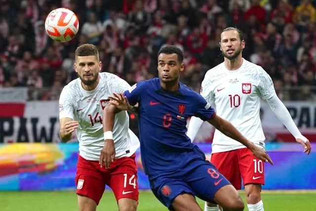 HANDFUL: Leeds United's Mateusz Klich, left, looks to keep tabs on Netherlands forward and opening goalscorer Cody Gakpo, centre, a player the Whites tried to sign, in Thursday evening's Nations League clash in Warsaw. Photo by JANEK SKARZYNSKI/AFP via Getty Images.