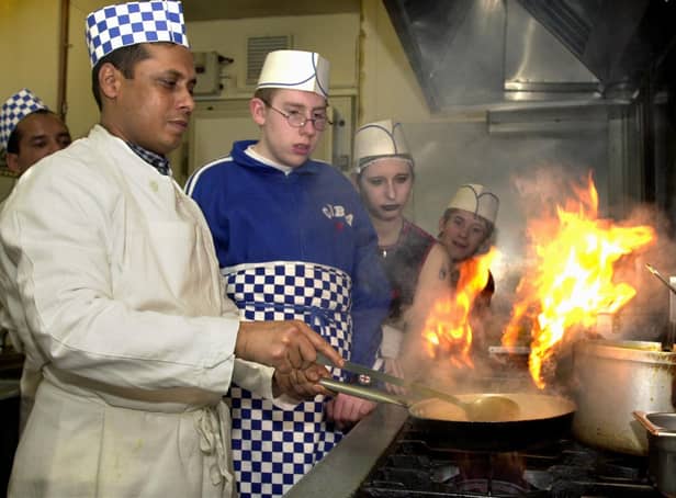 Chef Anwar Miah at the Ruchee restaurant demonstrates the art of cooking to students from Elmete Wood special school in Roundhay, from left, James Sanderson, Kimberley Knowles and Simon Tunstall, on December 5, 2002.