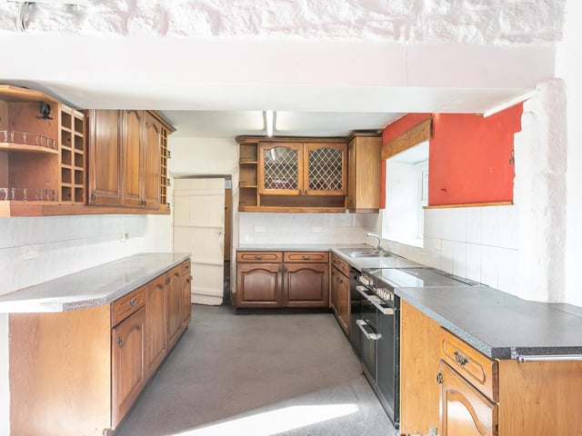 The kitchen with diner in the farmhouse has a log burner, and a large pantry store.