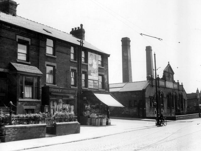Shops and houses on corner of Compton Road and Hudson Road in June 1939. Popple Ladies and childrens outfitters and greengrocers shop with awning up and boxes stacked on pavement. Burton's clothing factory is on opposite corner.A boy with a bicycle stands at edge of road by two belisha beacons.