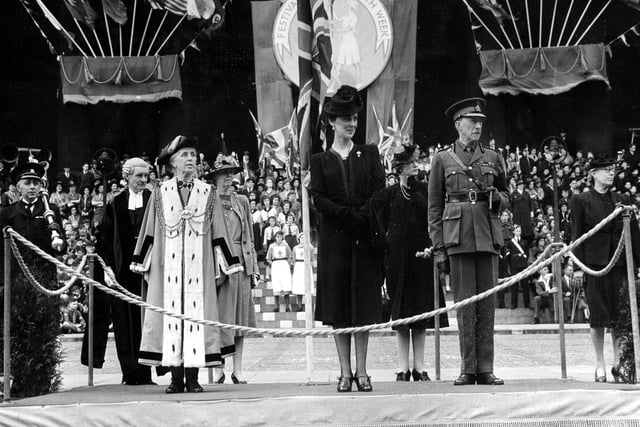 In the centre of the view is the Duchess of Kent, taking the final march past salute at the end of the Festival of Youth in November 1943. The Duchess was Princess Marina of Greece before her marriage in 1934 to George, Duke of Kent. He had died in a plane crash the previous year on August 25, 1942. The lady on the left is Lord Mayor Jessie Beatrice Kitson, standing behind is Miss E. Lupton, Lady Mayoress.