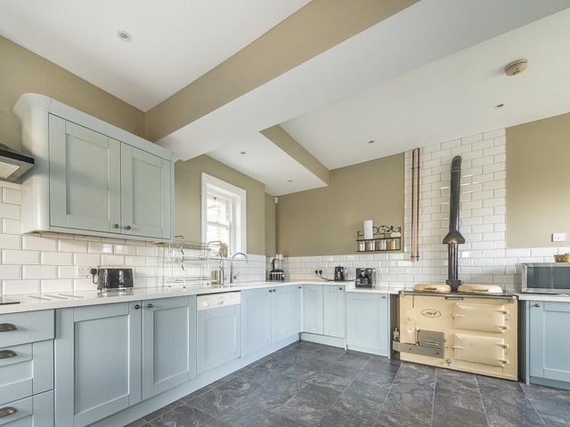 Sat to the rear is a breakfast kitchen with a range of attractive shaker-fronted units, plus a utility room with a side access door.