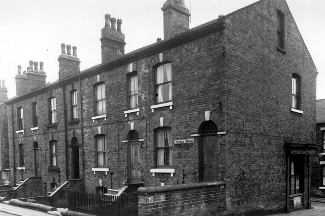 This view looks from Clyde Street onto back-to-back houses on Victoria Square in June 1959. These properties have small yards with steps leading down to basement entrances. Number 2 has leaded lights in the lower window and fanlight. A shop on the corner of Clyde Street and Walkers Place is visible towards the right.