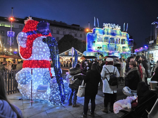 Shoppers stop for a photo with a Christmas celebrity - a large illuminated snowman.