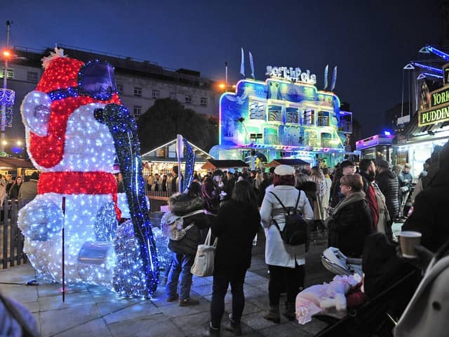 Shoppers stop for a photo with a Christmas celebrity - a large illuminated snowman.