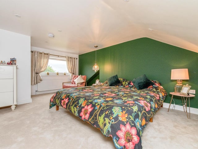 An extremely spacious, carpeted bedroom is one of four within the property.