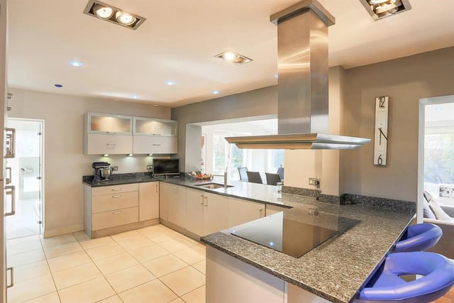 The stylish kitchen is fitted with contemporary units to three sides, incorporating a breakfast bar, four ring induction hob and a built-in oven.