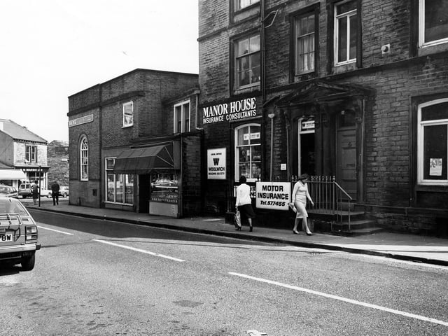Manor House Street showing from left Barclays Bank, then W.H. Bowman, butchers, Manor House insurance consultants including the local office of the Woolwich Building Society, and on the right the offices of St. John's Ambulance Brigade.