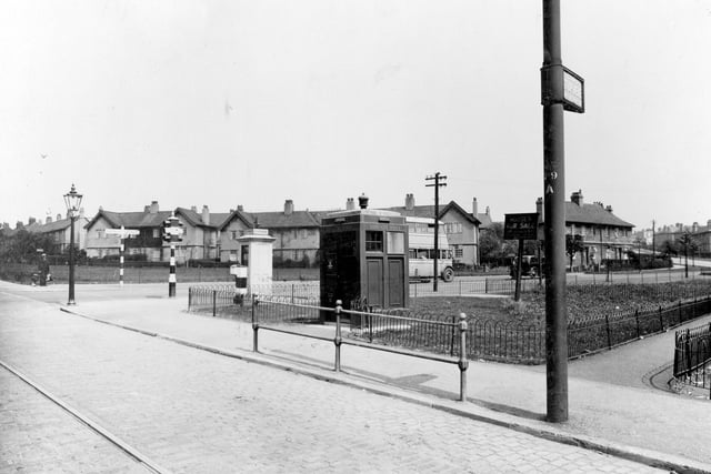 The junction of Stainbeck Road and Meanwood Road, which is on the left of the view. Scene includes a street lamp and a finger signpost pointing to Headingley towards the left, Chapeltown and Moortown going right. A traffic light, telephone box, tram stop and barrier can be seen. Also a police box which is in the centre. It was used by the police on patrol to call the police stations, before personal radios were available. Pictured in  June 1936.