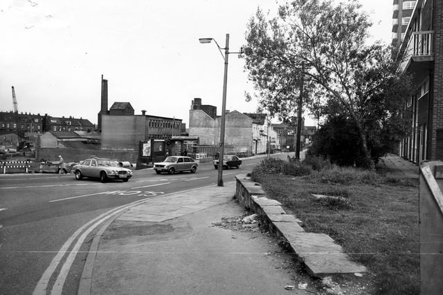 Armley Road looking east, seen from the junction with Crab Lane in September 1980. The white-fronted building in the centre is the Nelson public house. On the left is a building site, in which a crane can be seen. On the right is a block of housing.