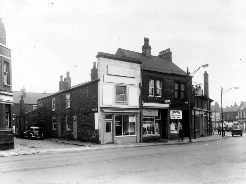 On the left of this view from June 1959 is Copley Yard where a car is parked. The two properties in view were part of the same premises as number 6 Tong Road, the pale fronted building in the centre of the view. This was an upholsterers and furnishers, business of R. Robinson. Number 4 follows to the right, this building is shared by Lilians hairdressers upstairs and G. Levine's tailors downstairs. Number 2a is the Crown Meat Market with The Crown Hotel at number 2 Wellington Road is visible on the right edge.