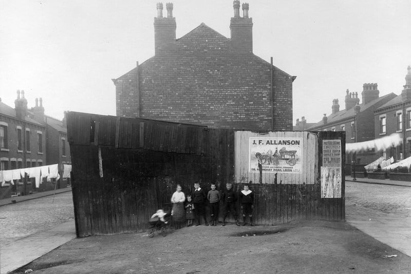 A group of children pose for the camera in front of an outside toilet block at the end of a row of terraced housing separated by Arundel Street and Gledhow Road in September 1915.
