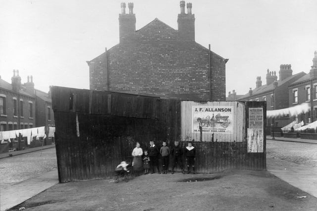 A group of children pose for the camera in front of an outside toilet block at the end of a row of terraced housing separated by Arundel Street and Gledhow Road in September 1915.