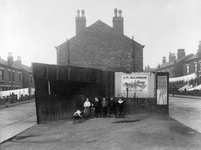 A group of children pose for the camera in front of an outside toilet block at the end of a row of terraced housing separated by Arundel Street and Gledhow Road in September 1915.