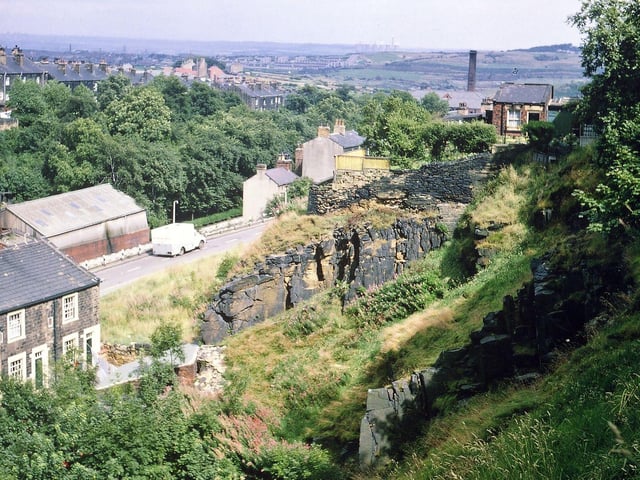The face of the old town's quarry behind the Rock Inn from Troy Road. Part of Albert Road can be seen, aa well as Station Road Park, Crank Mill chimney, New Bank Street and parts of Leeds in the distance, with Skelton Grange Power Station on the far horizon.