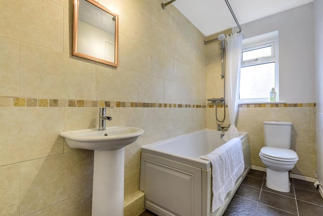 The house bathroom has a three-piece suite with a bath-over-shower, sink and toilet.