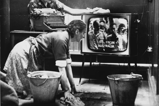 6.30am on November 24, 1966 and two cleaners, Mrs. Annie Burke (kneeling) and Lily Backhouse, watch a great moment in TV history - a live transmission for the first time of pictures direct from Australia via satellite.