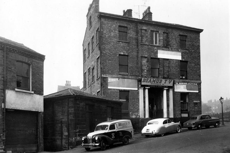 Hanover House pic turdd in September 1959. It was locatedon the corner of Hanover Street and Denison Road, Hanover House, built around 1831, boasted one notable owner - 
 James Kitson, later Lord Airedale (1861 - 1870). Seen here, the house was used as a TV repair depot. It was the business of Beamur TV and the Hanover Television Repair Co. Vehicles parked outside include a company van.