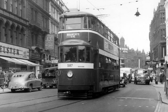 Looking east along Boar Lane in September 1955 showing tram no.587 on route 15 to Whingate. Shops on the left include Elster Shoes, the White Rose Milk Bar, Lancashire & Yorkshire Stationery Co. Ltd. and Spinks restaurant, while among those on the right is Fairburn's White Horse restaurant.