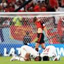 DOHA, QATAR - NOVEMBER 27: Morocco players pray after their 2-0 victory while Charles De Ketelaere of Belgium leaves the pitch after the FIFA World Cup Qatar 2022 Group F match between Belgium and Morocco at Al Thumama Stadium on November 27, 2022 in Doha, Qatar. (Photo by Buda Mendes/Getty Images)