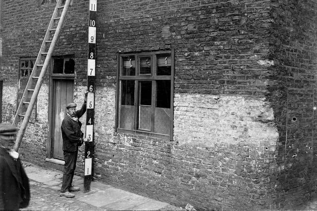 A property, located off Woodhouse Lane, is being measured prior to demolition in August 1906.