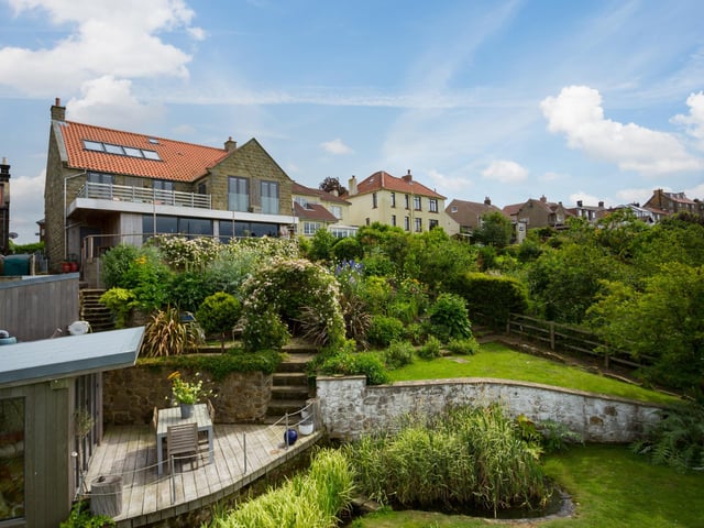 Tiered lawned gardens include established trees and shrubs.
