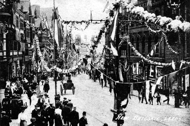 A postcard showing New Briggate decorated with flags and bunting for the Royal visit.